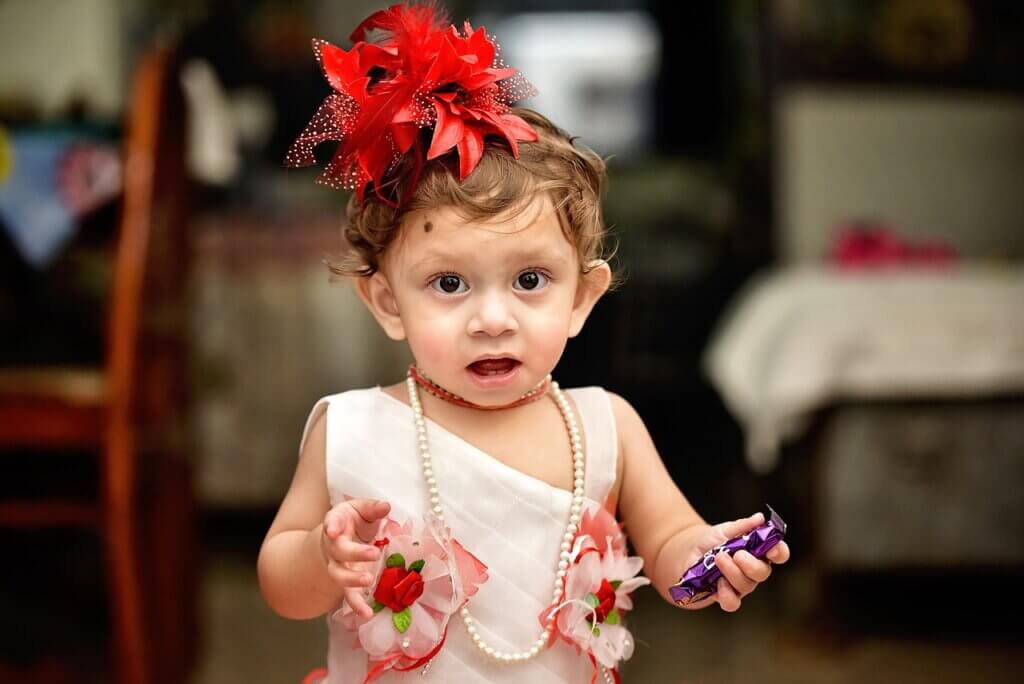 a girl toddler holding a candy bar

