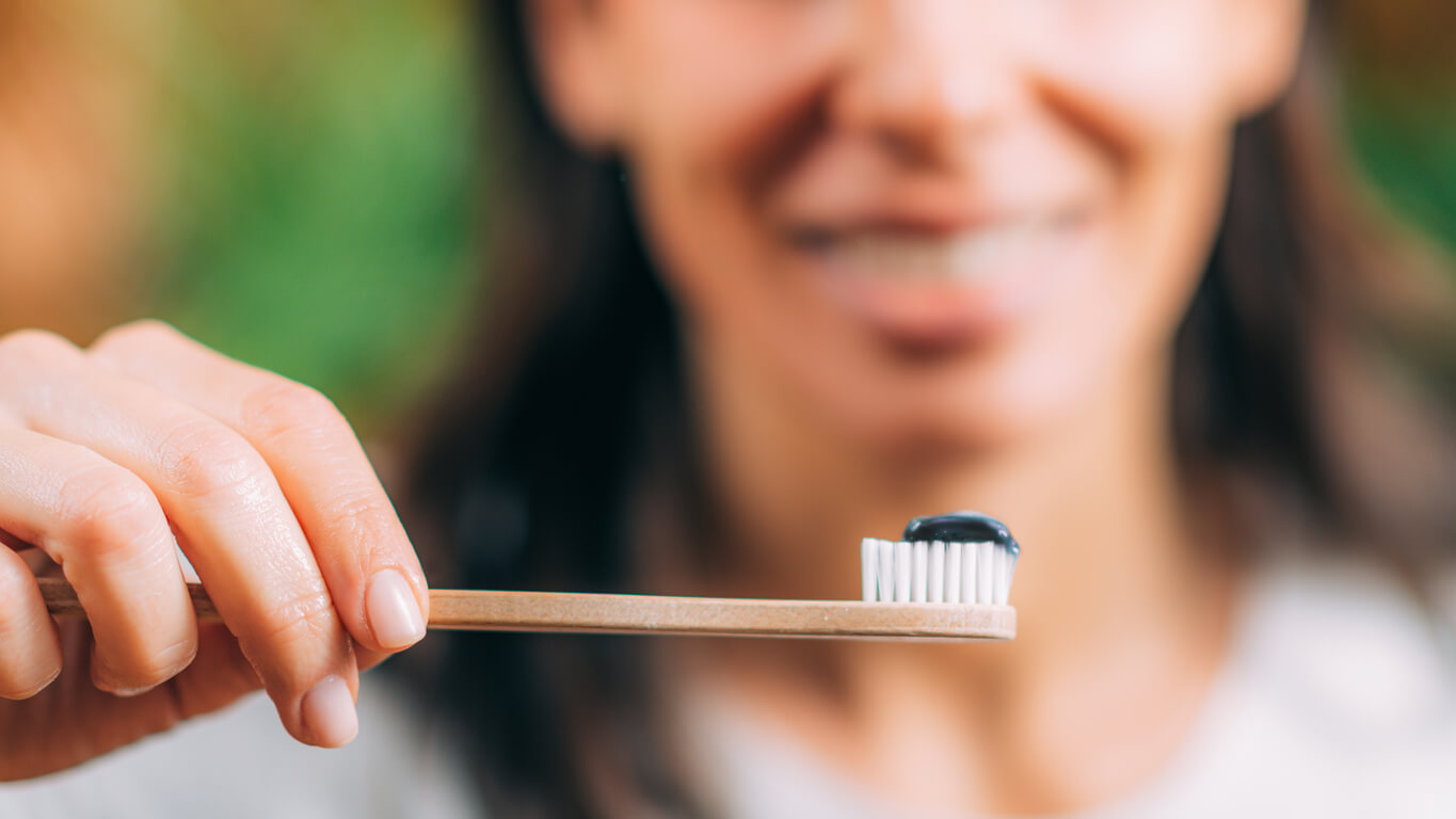 Toothpaste with Black Charcoal on Wooden Toothbrush.