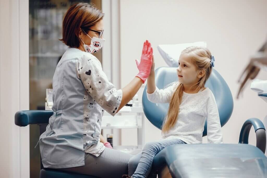 Child and dentist giving high-five for being a good dental patient