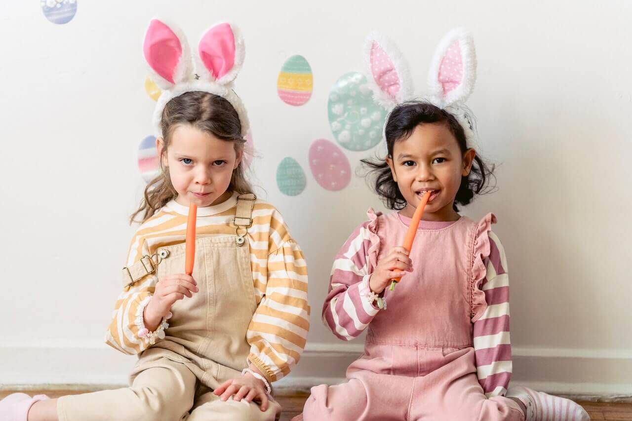 Two little girls eating carrots - foods for healthy teeth