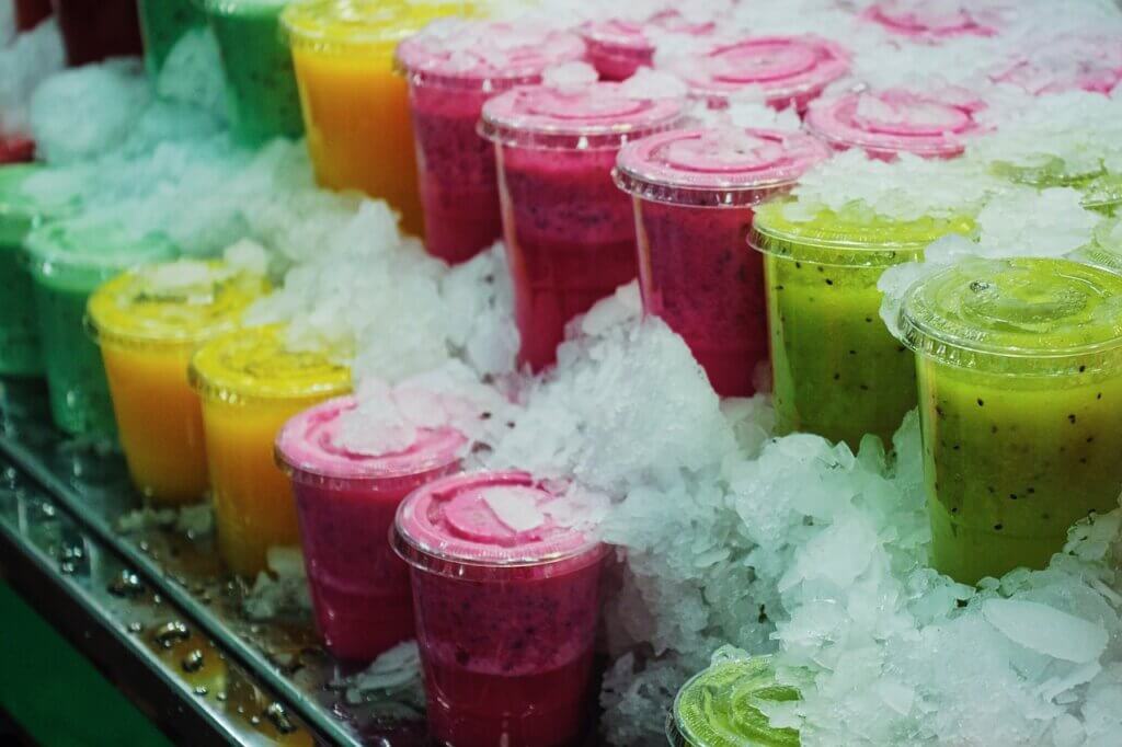 an array of fruit smoothies in plastic cups