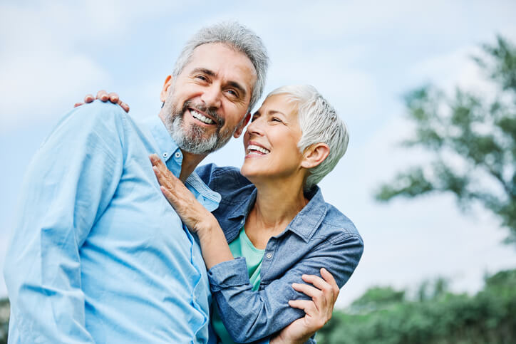 senior couple with dental implants smiling and being active