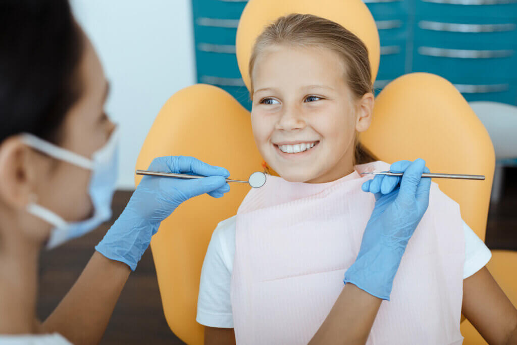 happy little girl sitting in dental chair