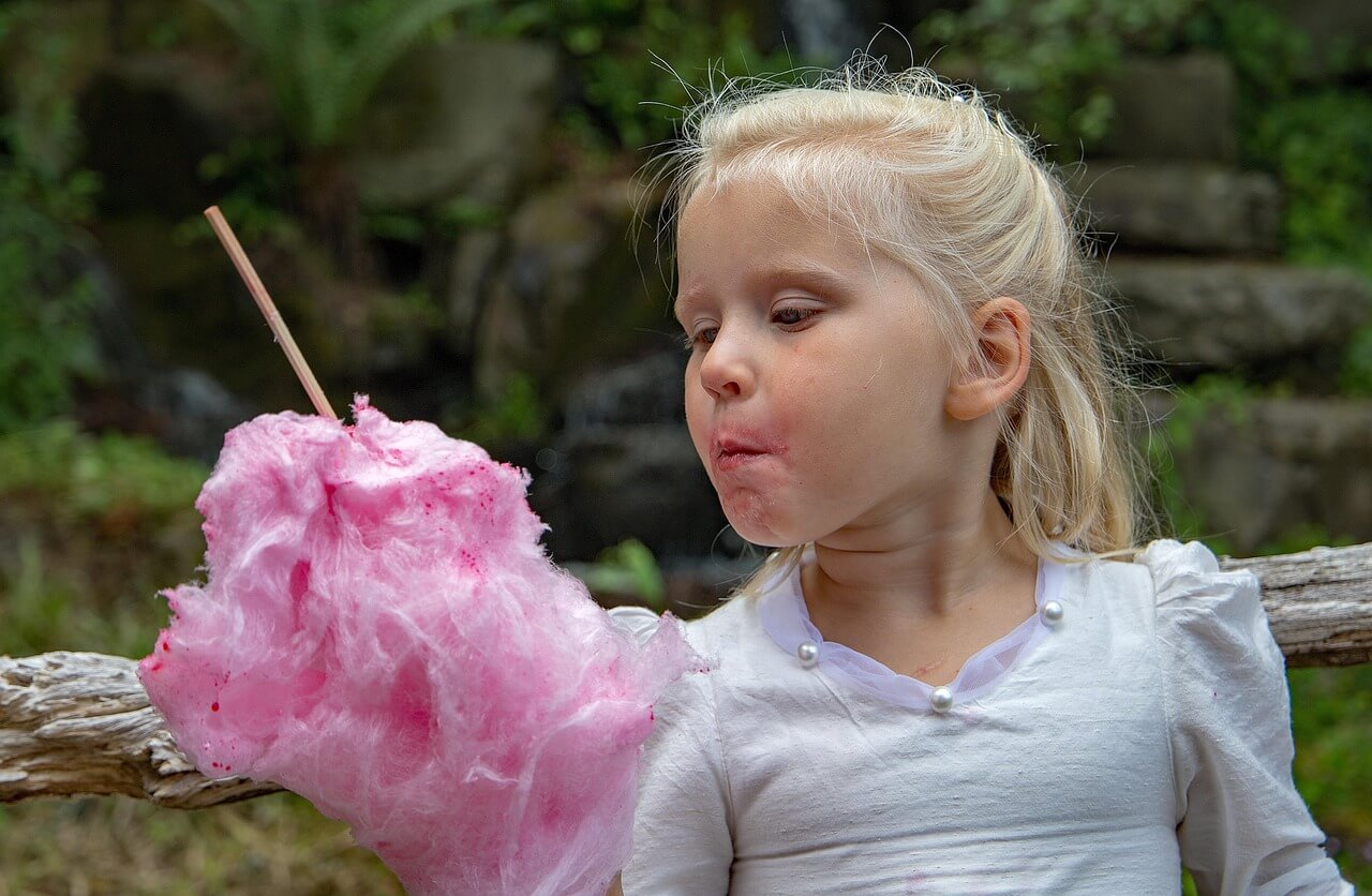 a little girl eating cotton candy